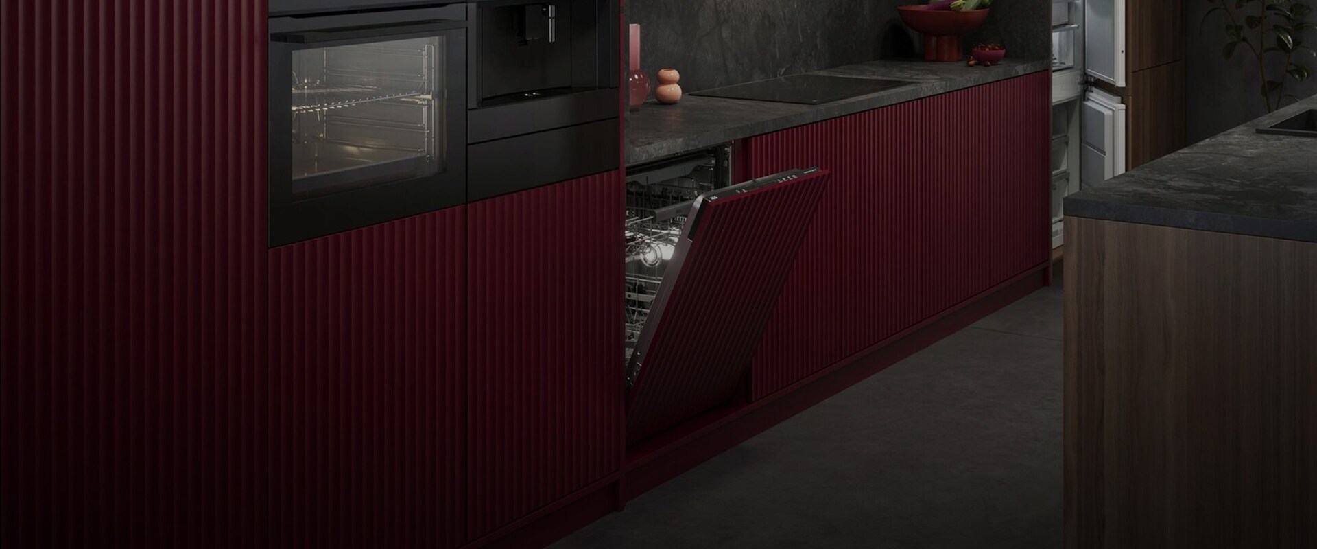 Stilren kjøkkenvegg med integrerte hvitevarer fra AEG, inkludert ovn, kaffemaskin og en halvåpen oppvaskmaskin med røde, rillede fronter.